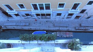 A multi-story building with balconies, a water feature, and potted plants. - Panoramic view in San Marco overlooking the rooftops (Venezia)