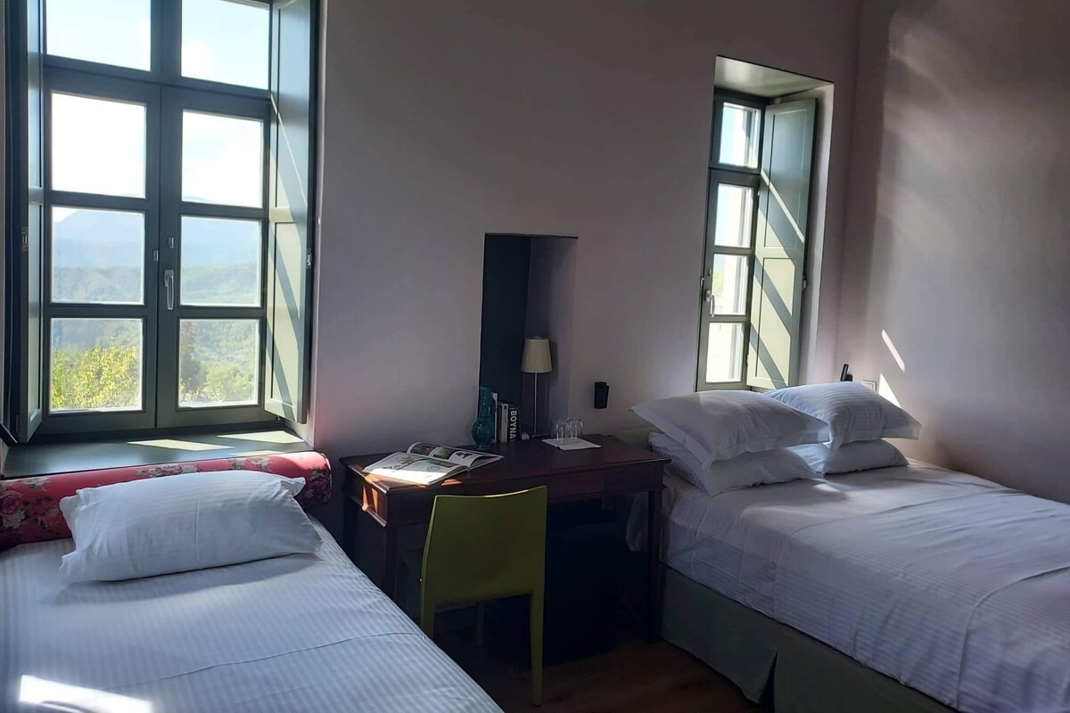 Une chambre avec deux lits, un bureau et une chaise.