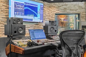 A sound mixing console with two large speakers, a laptop, and a monitor displaying audio software. - Above Nashville West End Rhythm | Music Studio | Premium Location | Luxe (Nashville)