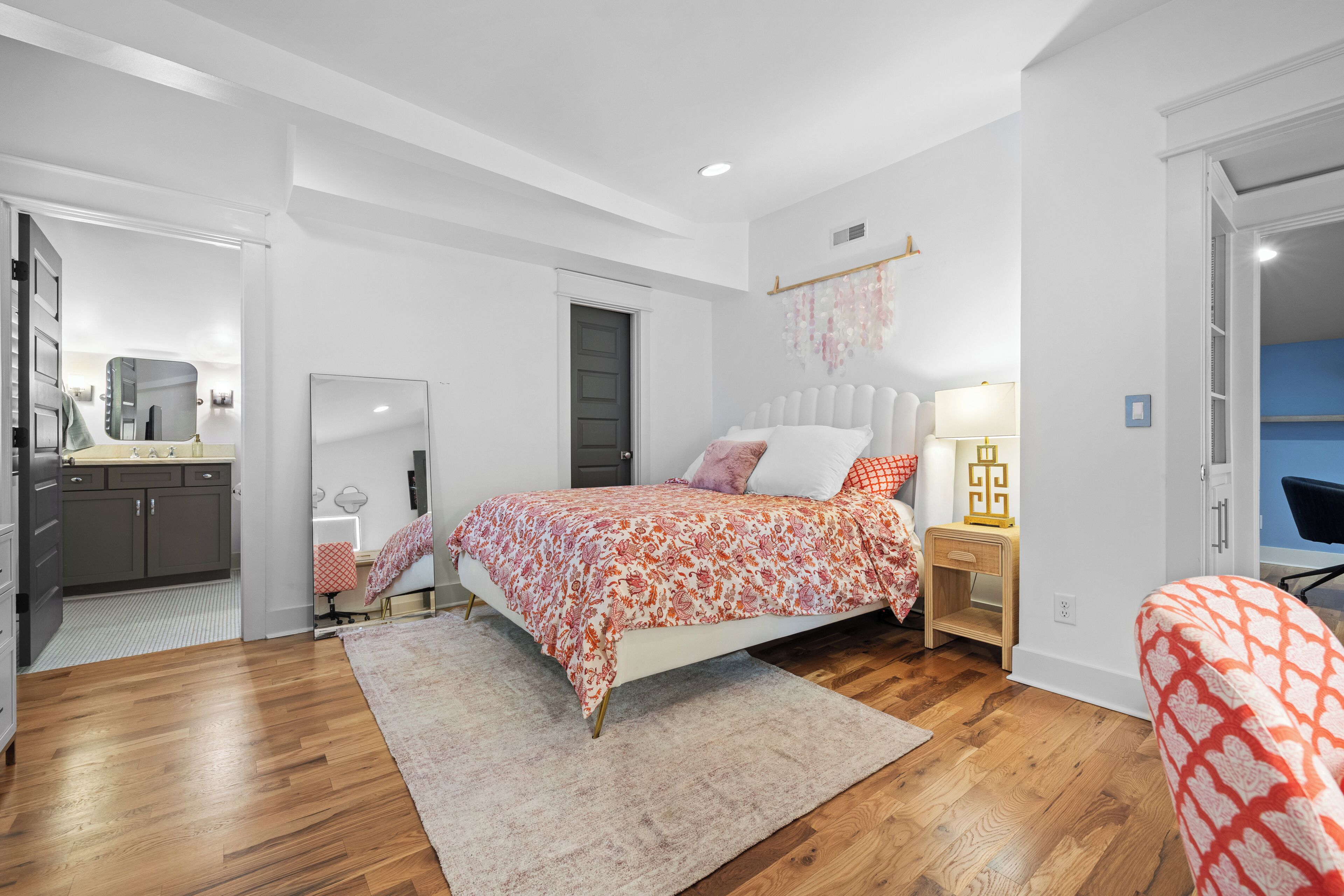 Une chambre à coucher avec un lit, des tables de chevet, un bureau et une chaise.