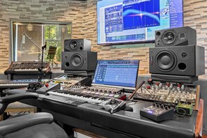 Una consola de mezcla de audio profesional con varios monitores, altavoces y paneles de control.