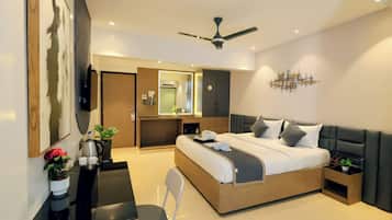 Una habitación de hotel moderna con cama, escritorio, silla y ventilador de techo.