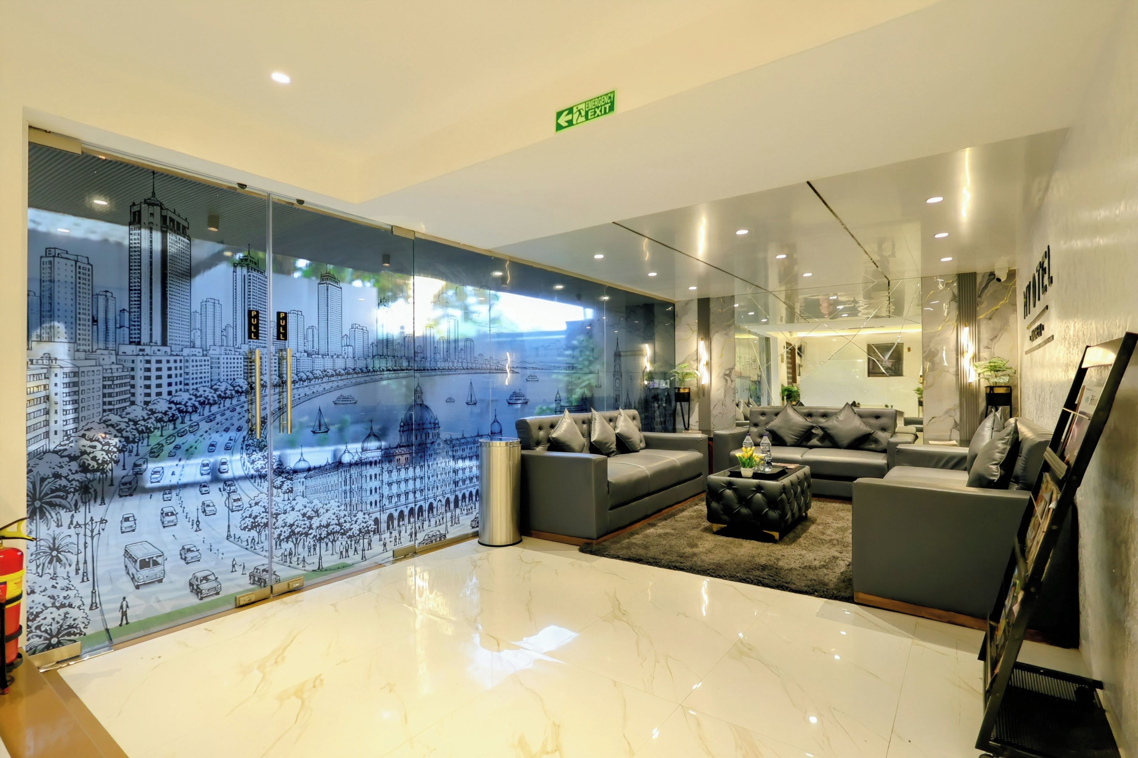 Un moderno vestíbulo de hotel con un gran mural de paisaje urbano, asientos confortables y una señalización clara de salida de emergencia.