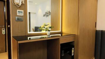 A modern bathroom with a large mirror, wooden vanity, and a built-in heater.