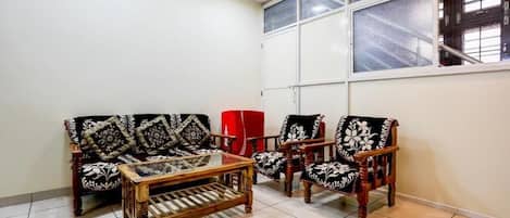 A room with a sofa set, a coffee table, and two chairs.