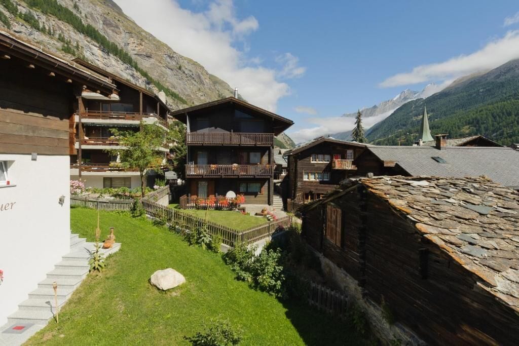 Ein traditionelles Chalet mit Holzfassade, einem Balkon und einem Steindach.