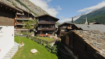 Ein traditionelles Chalet mit Holzfassade, einem Balkon und einem Steindach.