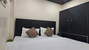A bedroom with a bed, a ceiling fan, and a wardrobe.