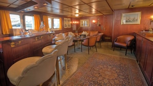 A cozy interior with a bar area, seating, and a patterned rug. - Sanssouci Star - Exclusive Island Cruise (Flensburg)