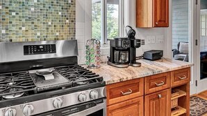 A kitchen with a stainless steel stove, wooden cabinets, and a coffee maker on the counter. - NEW RENTAL!  Visit 'Lazy Lake Days"! (Huddleston)