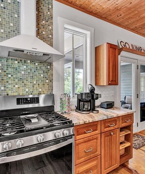 A kitchen with a stainless steel stove, wooden cabinets, and a coffee maker on the counter. - NEW RENTAL!  Visit 'Lazy Lake Days"! (Huddleston)