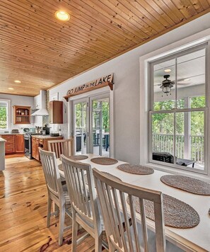 A dining area with a long table, white chairs, and a view of the outdoors. - NEW RENTAL!  Visit 'Lazy Lake Days"! (Huddleston)