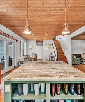 A kitchen with a wooden ceiling, pendant lights, a marble countertop, and a shoe rack with various shoes. - NEW RENTAL!  Visit LAZY LAKE DAYS! (Huddleston)