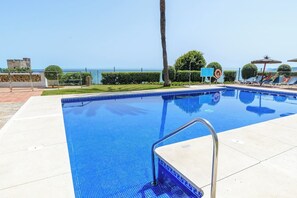 A swimming pool with a metal ladder, surrounded by a fence, with a clear view of the sea in the background. - Beachfront Penthouse, Casares (Casares)