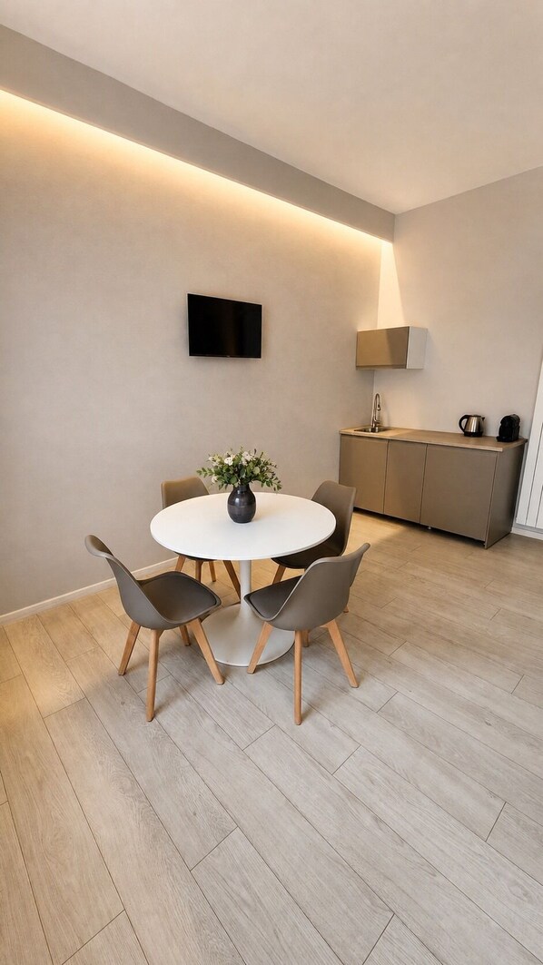 A modern kitchen with a built-in oven, a sink, and a coffee machine.
