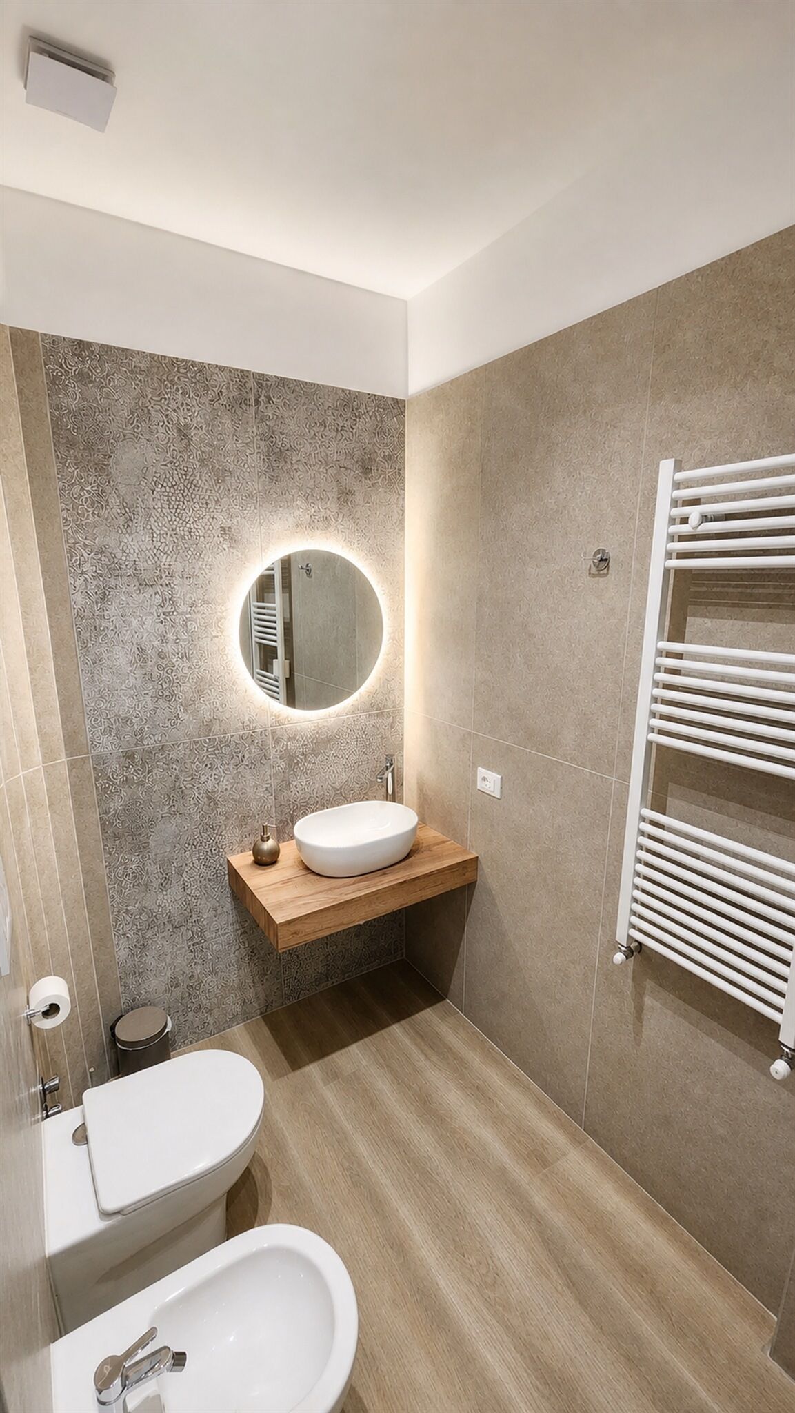 A modern bathroom with a freestanding sink, a toilet, and a bidet.