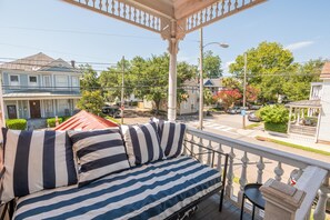 A balcony with a bed, a railing, and a view of the neighborhood. - Walk to King St | Spacious Charleston Stay (Charleston)