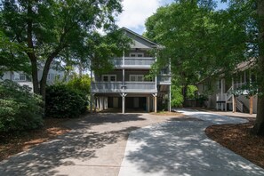 A two-story residential building with a covered front porch and a garage. - Hammock Haven | Walk to Marshwalk! (Murrells Inlet)