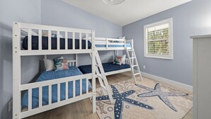A child’s room with bunk beds, a starfish rug, and a window with blinds. - Mollymawk Cottage: Peaceful Pool Home Near Beaches, Golf & Island Adventures (Sanibel)