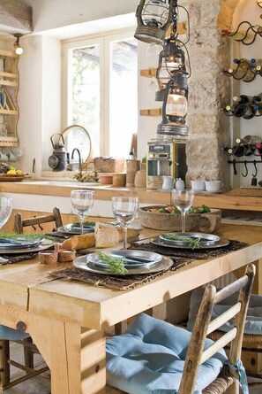 A wooden dining table set with plates, glasses, and a rustic centerpiece. - Aphrodite's Oasis with Private Pool (Pomos)