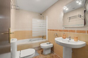 Un baño con bañera, inodoro y lavabo.