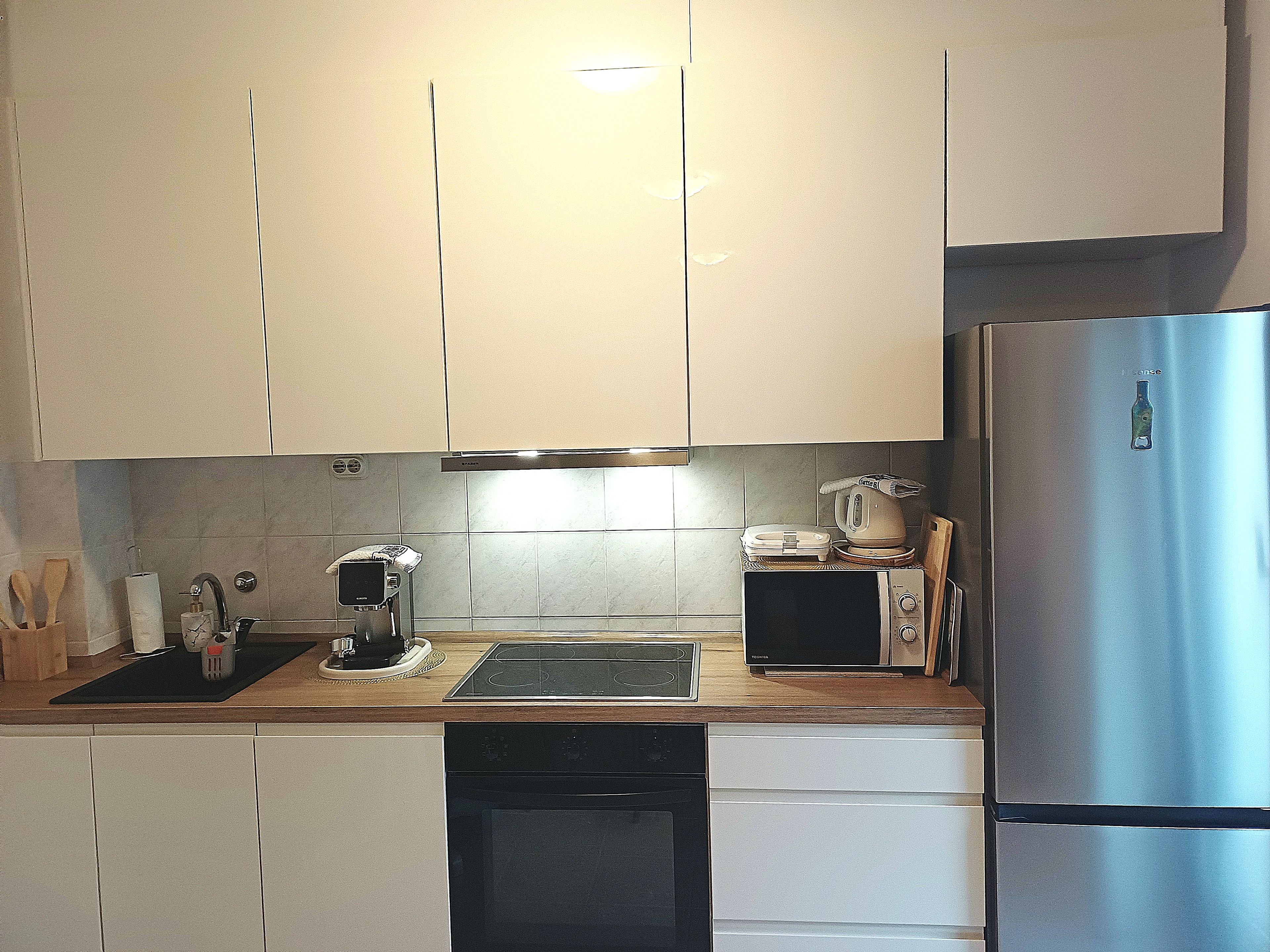 A modern kitchen with stainless steel appliances, a dishwasher, and a built-in oven.