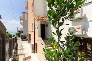 A narrow street with buildings, a gate, and a plant in the foreground. - Beach Nest (Split)
