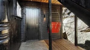Een houten deur met een metalen handgreep, een houten trap en een stenen muur.