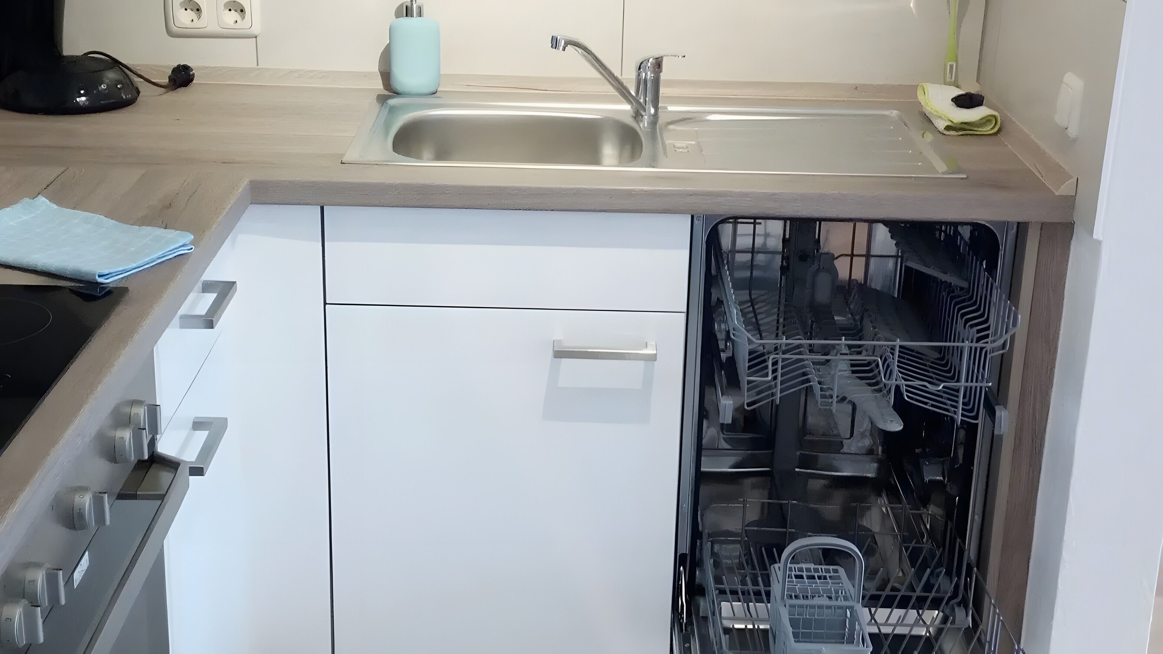 Una cocina con lavavajillas, un lavabo y una encimera.