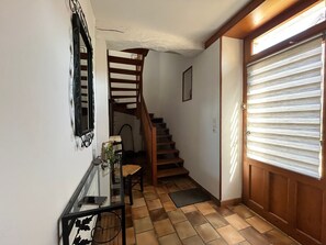 A hallway with a wooden staircase, a door with horizontal blinds, and a wall-mounted mirror. - Quiet cottage, pets allowed, parking - 6 guests (Chambon)