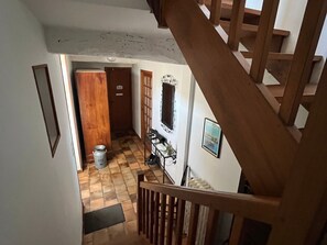 A staircase leading to a landing with a checkered floor, a metal container, and a door with a sign. - Quiet cottage, pets allowed, parking - 6 guests (Chambon)