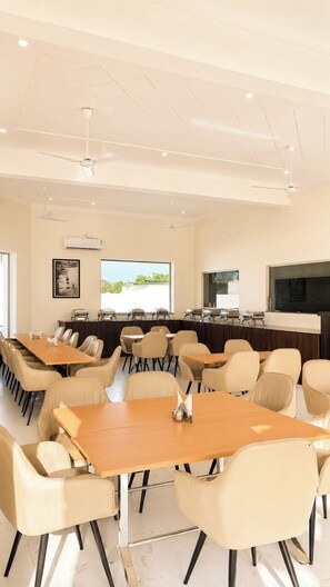 A conference room with multiple tables and chairs, a whiteboard, and a projection screen. - Corbett Vantara (Ramnagar)
