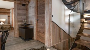 Ein modernes Interieur mit einer Holzwand, einer Glasstairnase, einer Küchenzeile und einem Bett.