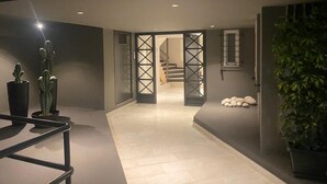 A hallway with a modern design, featuring a staircase, a potted plant, and a minimalist decor. - Premium 3 Bd Retreat in Neapoli-Lycabettus (Athina)