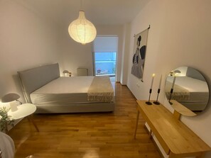 A bedroom with a bed, bedside table, lamp, and a large mirror. - Premium 3 Bd Retreat in Neapoli-Lycabettus (Athina)