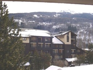A multi-story building with balconies, surrounded by snow-covered trees and mountains in the background. - Studio near funicular - 4 guests (Bourg-Saint-Maurice)
