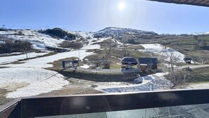 En liftstation med en sittlift, byggnader och ett snötäckt landskap.