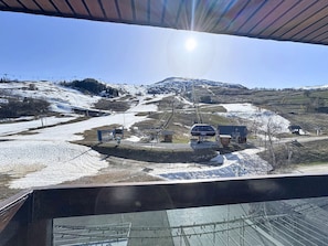 A ski lift station with a chairlift, buildings, and a snowy landscape. - Spacious apartment, central location - 8 guests (Le Corbier)