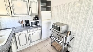 A compact kitchen with white cabinets, a microwave, a toaster oven, and a small countertop. - Air-conditioned apartment with beach access and terrace in Roses (Roses)