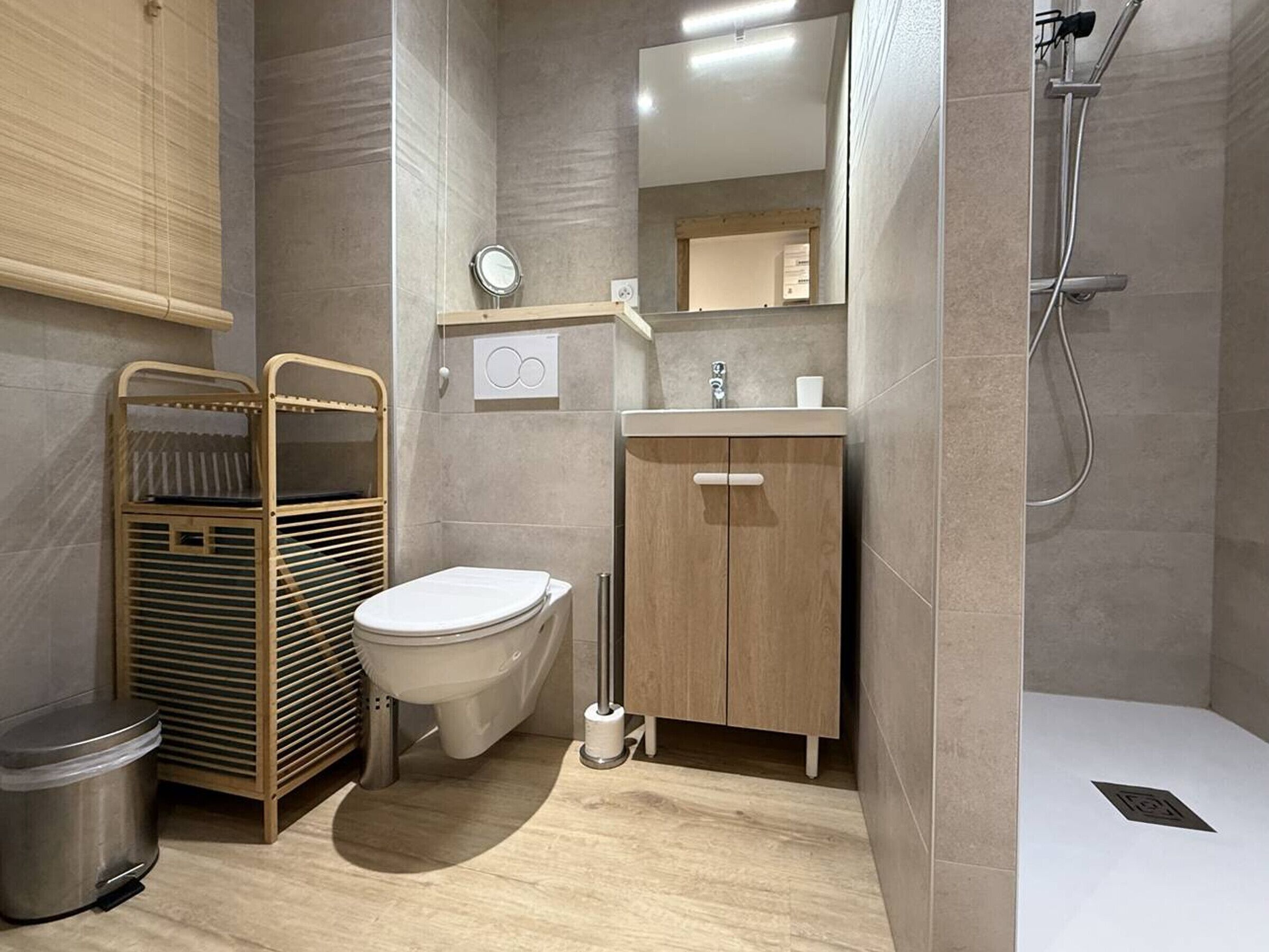 A modern bathroom with a toilet, sink, and shower.