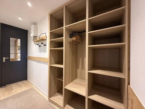 A walk-in closet with multiple shelves and hanging space, a mirror, and a door with a handle. - Bright studio with unobstructed view - 4 guests (Belle Plagne)