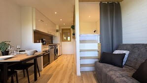 Ein gemütlicher Wohnbereich mit Küchenzeile, Essbereich und einer Couch.
