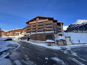 A multi-story building with balconies, a stone facade, and a snowy environment. - Bright studio with unobstructed view - 4 guests (Belle Plagne)