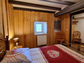 A wooden room with a bed, a window, a chair, and a small table. - Typical house, pets welcome - 6 guests (Chalmazel-Jeansagnière)