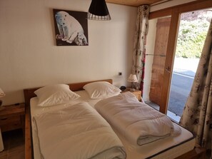 Un dormitorio con una cama, una mesita de noche, una lámpara y un cuadro en la pared.