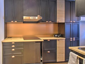 A kitchen with dark cabinets, a stainless steel range hood, and a wooden countertop. - Cozy apartment near center - 4/6 guests (Morzine)