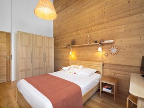 A wooden-paneled room with a bed, bedside table, and a shelf with decorative items. - New apartment near village - 4 guests (Le Monêtier-les-Bains)