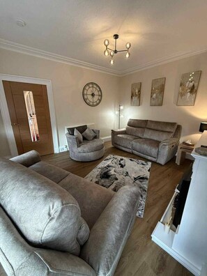 A living room with a sectional sofa, a round coffee table, and a patterned rug.