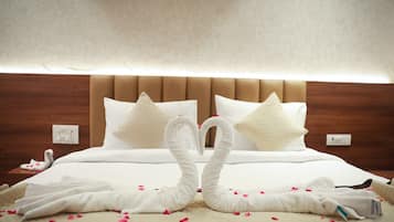 A hotel room with a bed, pillows, and a decorative swan made from towels.