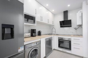 A modern kitchen with stainless steel appliances, a built-in oven, and a dishwasher.